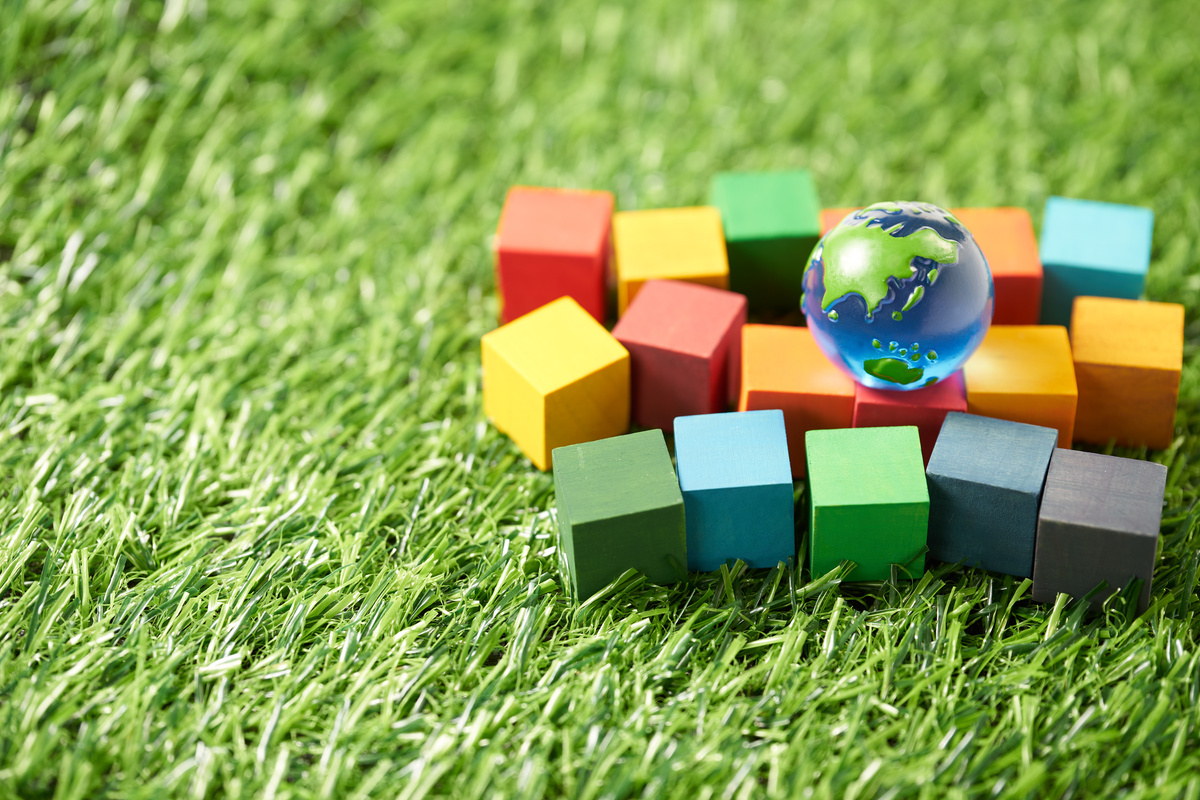 globe and a wooden cube stamped with the letters SDGs.